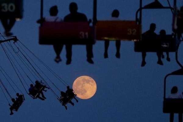 2. Tấm ảnh chụp tại công viên trò chơi State Fair Meadowlands, East Rutherford, New Jersey khiến người xem có cảm giác con người sắp chạm được đến mặt trăng.