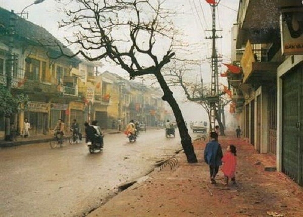 Cảnh thường thấy ở Hà Nội vào sáng ngày 1 Tết là đường phố vắng người, mưa bụi giăng trắng xóa, vỉa hè đầy xác pháo đỏ (trong hình là phố Khâm Thiên).