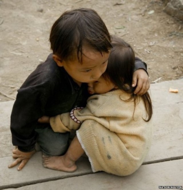 Cậu bé người Hmong ở Cán Tỷ, Quản Bạ, Hà Giang đang dỗ cô em bé tí của mình (Ảnh Na Sơn Nguyễn)