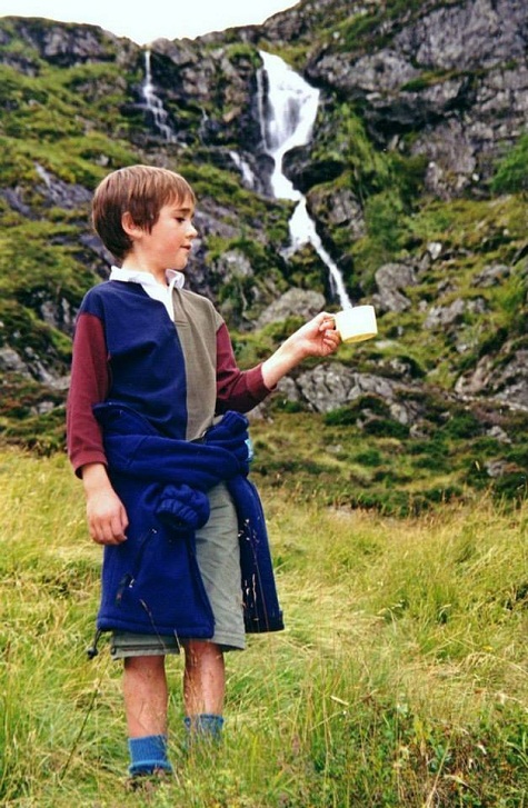 Dòng thác trên núi như dòng sữa chảy trọn vào ly nước của cậu bé.