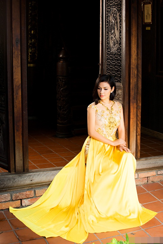 Nữ diễn viên Việt Trinh toát lên nét dịu dàng, sang trọng với áo dài vàng với thiết kế cầu kỳ, đuôi dài và hoa văn ấn tượng.