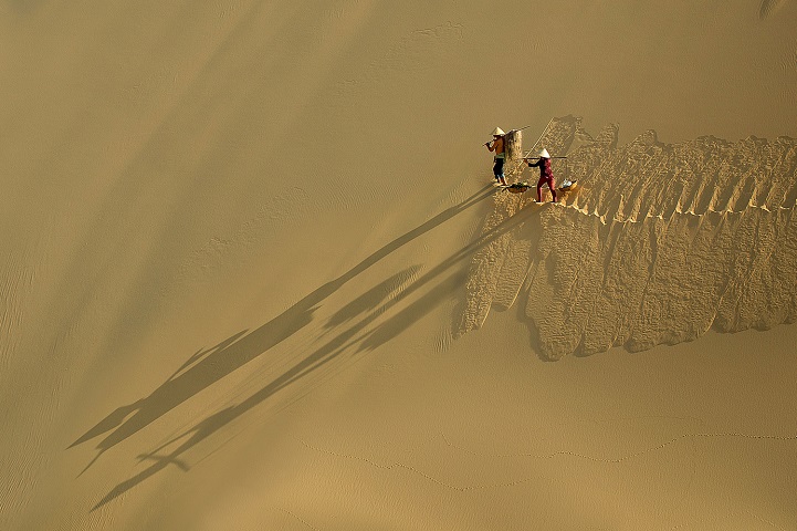 Bức ảnh này chụp tại một bãi ngang, để có thể đi làm ăn, kiếm sống, người dân vùng chài phải vượt qua những bãi cát mênh mông. (Ảnh Lê Minh Quốc)