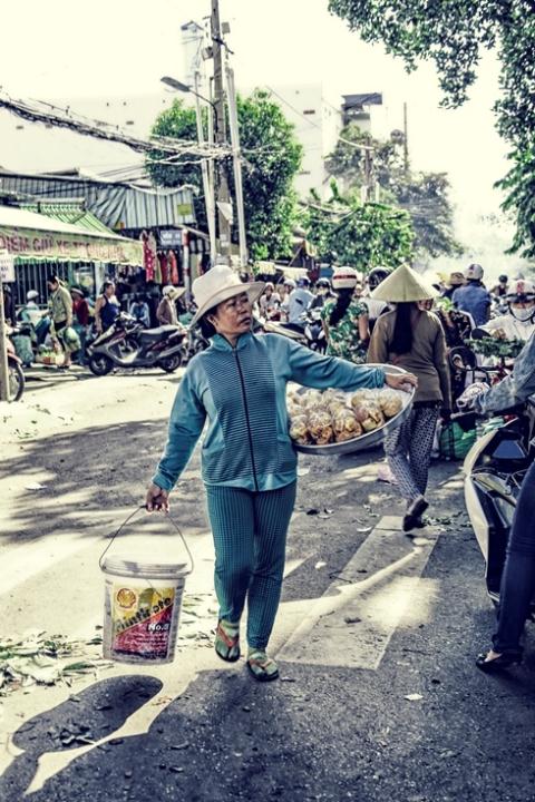 Quay trở về với Sài Gòn hoa lệ. Giữa phố phường tấp nập, hình ảnh người phụ nữ bán bánh dạo mưu sinh gợi lên sự nhọc nhằn, vất vả...