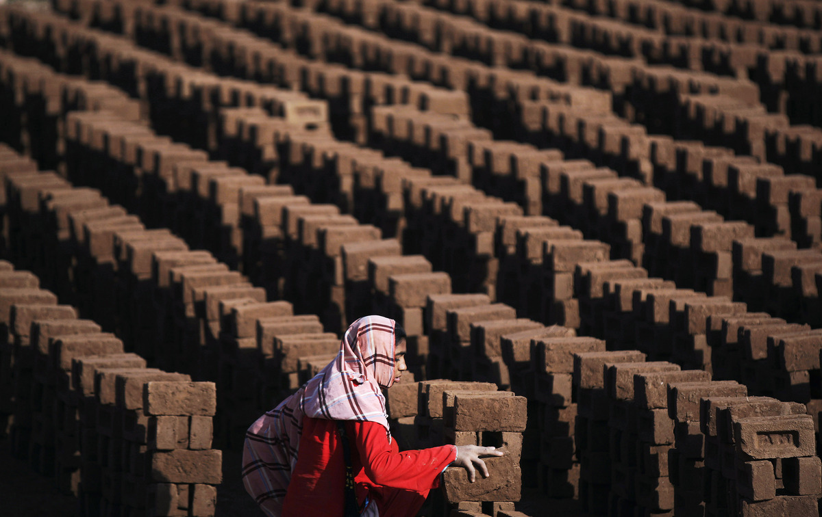 Một phụ nữ Pakistan đang xếp gạch tại một nhà máy gạch ở ngoại ô Islamabad, Pakistan  (Ảnh: Muhammed Muheisen/AP)