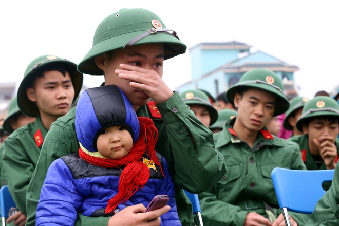 Tân binh Đỗ Thành Nam ở Đông Quang, Ba Vì, không kìm được nước mắt khi bế cháu - con của anh trai. Nam chia sẻ \'đây là lần đầu tiên xa nhà, rất nhớ những người thân, đặc biệt là cháu bé hàng ngày tíu tít ở bên\'.