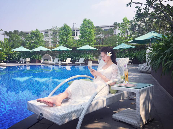 Hoa hậu Đặng Thu Thảo ngồi thư giãn bên hồ bơi trong ngày nắng ấm.