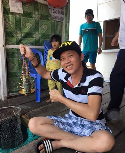 Nghệ sỹ Hoài Linh vui vẻ chụp hình tại Nha Trang \'Về với biển, cầm con tôm này chụp hình cho có không khí biển, chứ nghe giá mấy triệu một ký là tui thả nó xuống liền, không ăn đâu. Một ký này mua được 6-7 ký cá khô ăn được mấy tháng\'.
