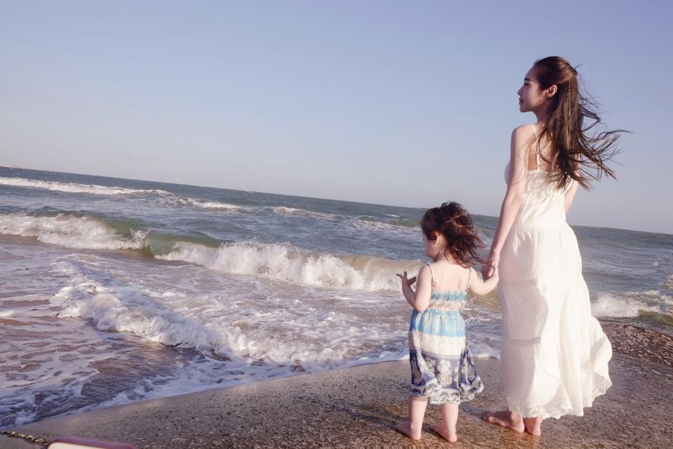 Elly Trần khoe ảnh chụp cùng con gái Cadie Mộc Trà trước biển cả mênh mông kèm dòng chú thích \'cô Trà quậy banh nhưng sợ cát lún chân\'.