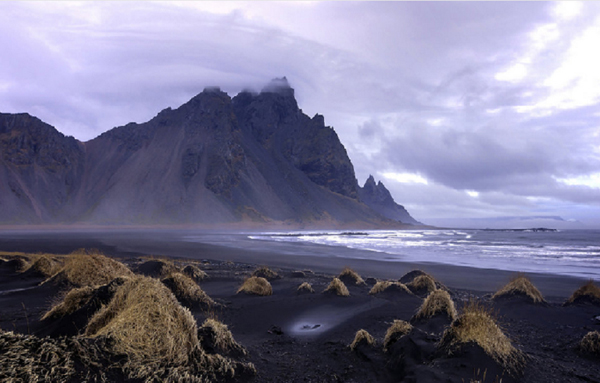 Biển Stokksnes, Stokksnes, Iceland: Bờ đá sừng sững hòa cùng với núi Vestrahorn hùng vĩ bên trên tại bãi biển Stokksnes là nơi hoàn hảo để du khách đắm chìm trong ánh hoàng hôn.