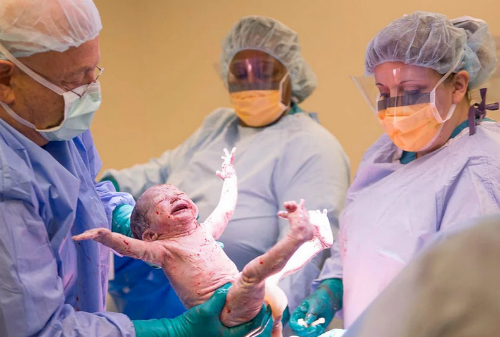 Em bé giơ 2 tay như để chào mừng sự ra đời của mình (ảnh: People)