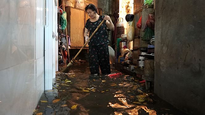 Nước kéo theo rác bẩn trôi vào lòng nhà dân trong khu phố cổ chật trội. Mỗi chuyến ô tô chạy qua, nước và rác thải trôi bồng bềnh vào nhà khiến những người dân khốn đốn
