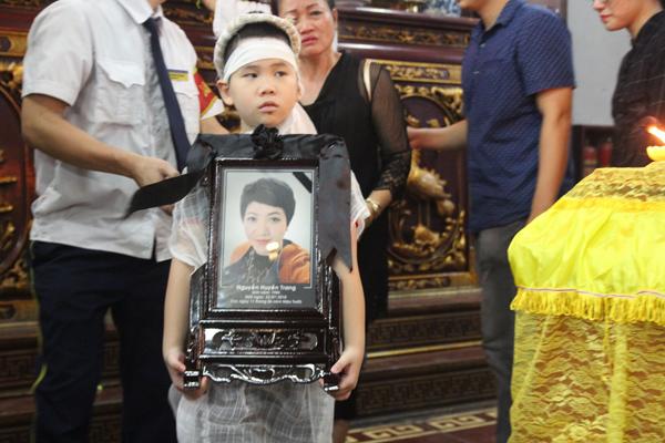 Con trai chị Trang ôm di ảnh mẹ như muốn mau mau đưa mẹ về nhà...