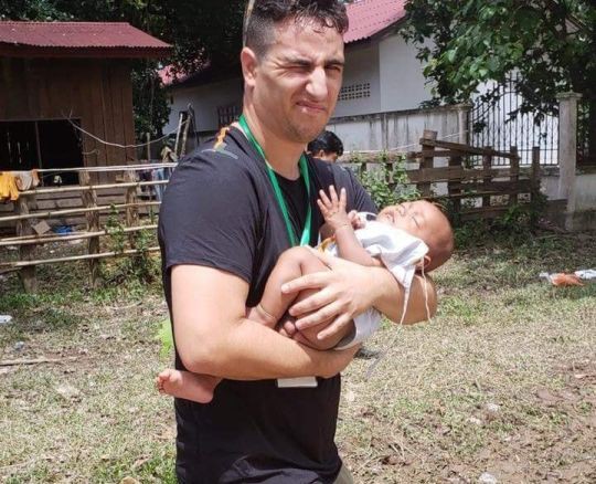 Tình nguyện viên Michael bế đứa bé