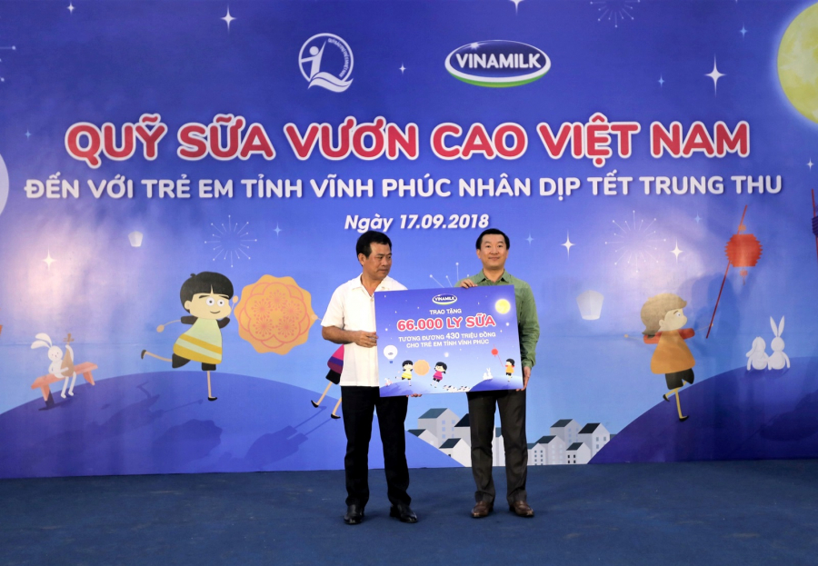 Ông Đỗ Thanh Tuấn - Giám đốc Đối Ngoại Vinamilk trao bảng tượng trưng 66.000 ly sữa cho đại diện tỉnh Vĩnh Phúc