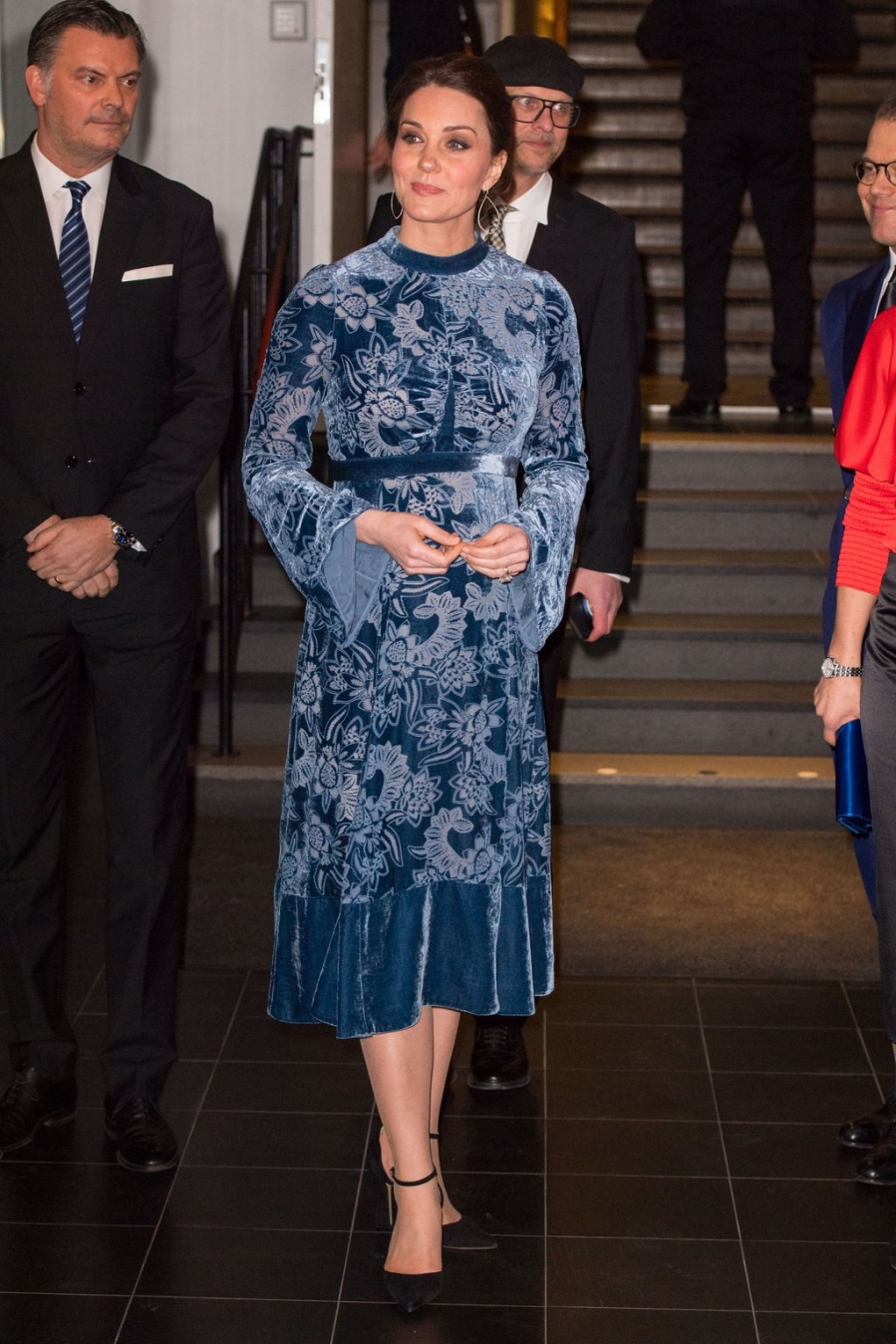 Ở các sự kiện trong nhà, vợ của hoàng tử William thường xuyên chọn kiểu tóc búi thấp, đeo khuyên tai dài để trông gọn gàng và quý phái hơn. Trong chuyến thăm bảo tàng ở Thụy Điển, công nương Kate chọn chiếc váy nhung dáng xòe màu xanh dương với họa tiết hoa chìm của thương hiệu Erdem .