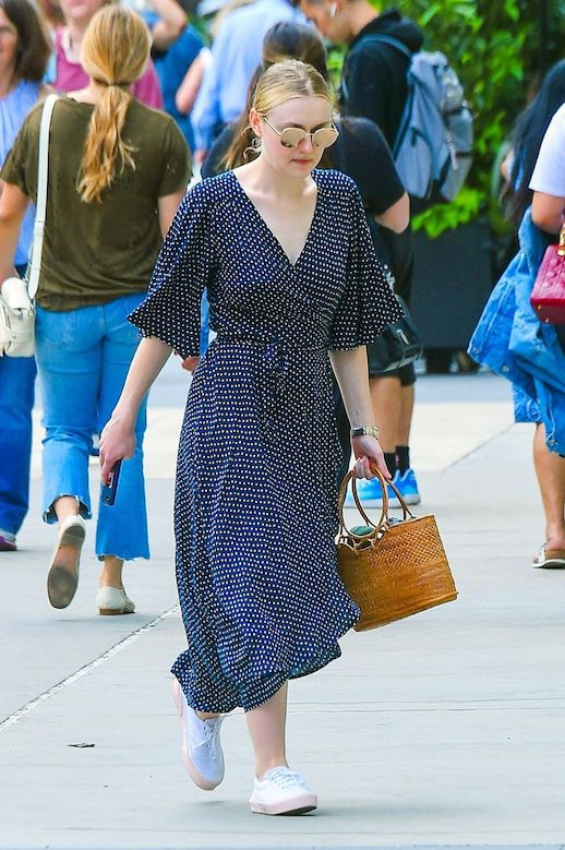 Khi diện váy quấn chấm bi hợp mốt mùa hè, Dakota Fanning có được tổng thể cá tính với cách phối giày thể thao và giỏ đan xinh xắn.