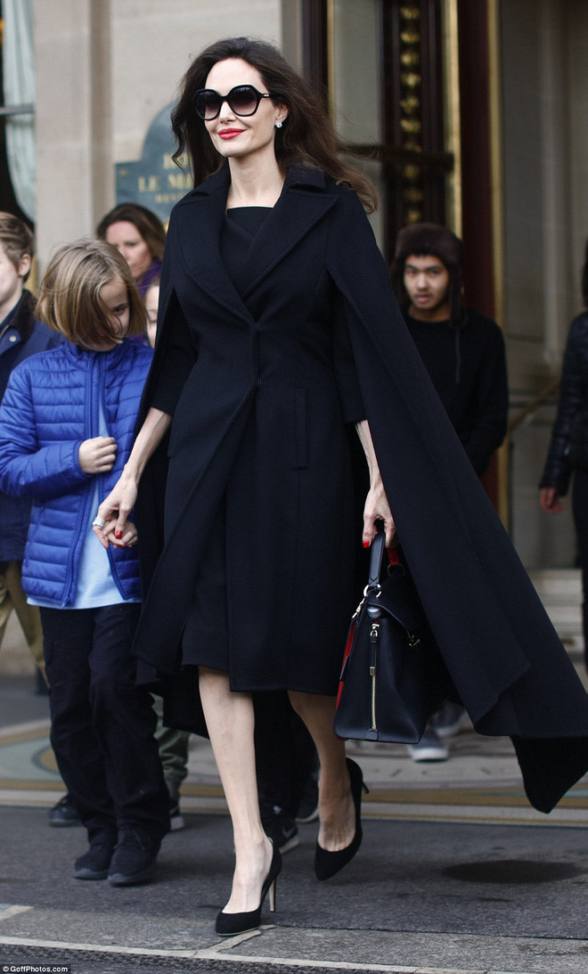 Angelina Jolie luôn được đánh giá là mỹ nhân có gout thời trang đẹp sang trọng, đúng chất minh tinh Hollywood. Chỉ đơn giản là váy đen kết hợp áo khoác dáng dài, cô thực sự tỏa sáng với vẻ tươi tắn, sang chảnh. Phụ kiện đi kèm set đồ là kính mắt, túi xách và giày gót nhọn. 