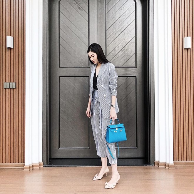 Á hậu Việt Nam 2012 còn ''ghi điểm'' khi mix bộ suit kẻ với giày đính nơ, điểm xuyết bằng chiếc túi Hermès gam màu nổi bật.  