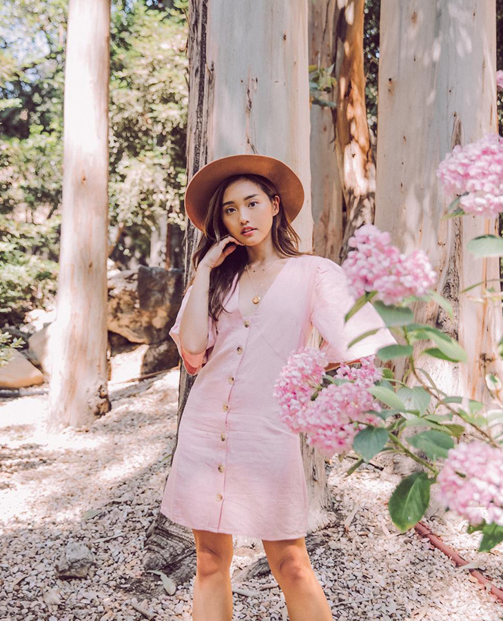 Beauty blogger Jenn Im đem đến set đồ theo phong cách đồng quê với chiếc đầm ngắn cài khuy màu hồng pastel và mũ rộng vành