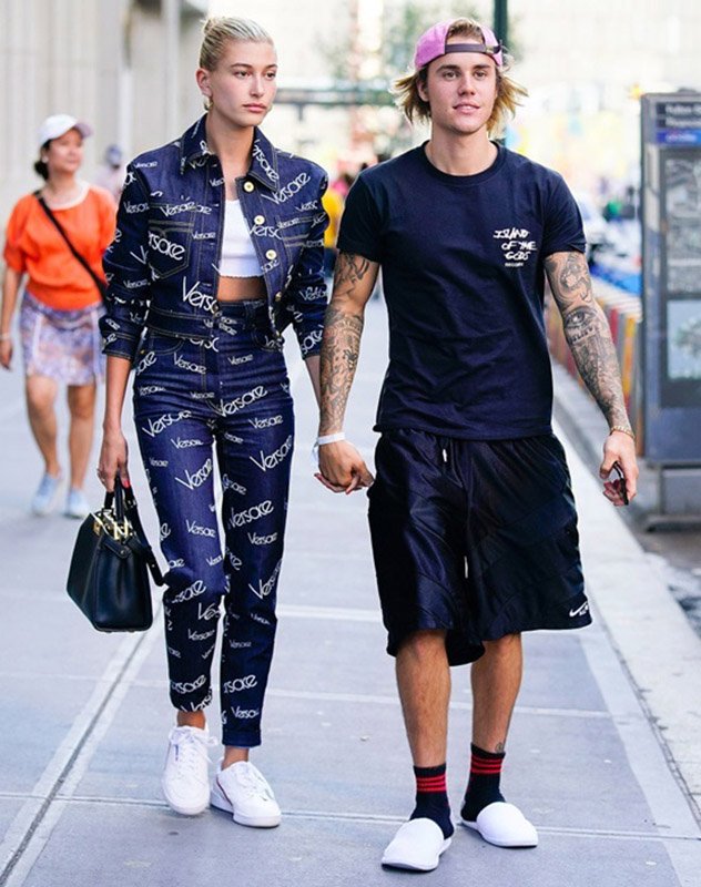 Justin chọn áo phông cùng quần thể thao, trong khi bạn gái anh diện bộ denim của Versace, kết hợp túi xách cổ điển. Cả hai cùng kết hợp sắc xanh tím than và sneakers trắng.   