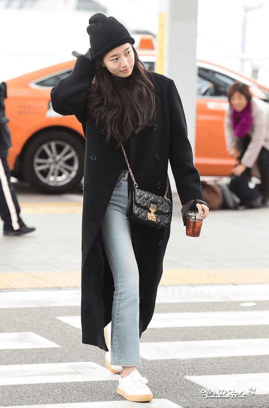 Suzy có phong cách thời trang đơn giản nhưng không kém phần sang trọng. Cô nàng diện áo khoác màu đen cổ điển và tự tin để mặt mộc ra sân bay.    