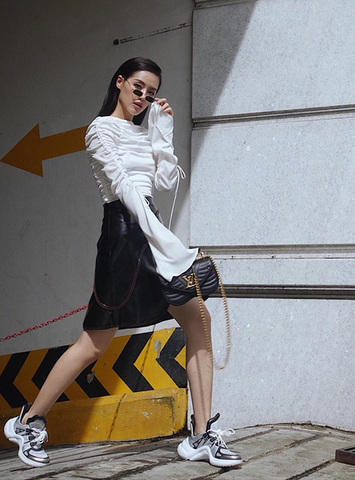 Khánh Linh tiếp tục chứng tỏ là fashionista thượng thừa khi diện bộ váy đen trắng nữ tính với túi xách và sneakers rất mạnh mẽ của Louis Vuitton.    