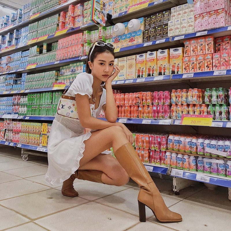 Dù là đi siêu thị sắm đồ, Quỳnh Anh Shyn cũng chứng minh gu thời trang xứng tầm fashionista với bộ đầm trắng tay phồng, phối cùng boots da và túi sắc Louis Vuitton sành điệu.    