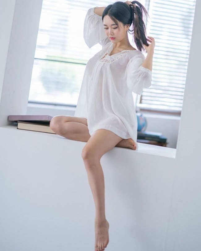 Người mẫu tên Kyung Hee lại mặc sơ mi trắng kiểu “giấu quần”, mà thực ra cũng chẳng có bất cứ chiếc quần nào bên trong, chỉ thấy đôi chân buông thõng rõ hững hờ của người đẹp.    