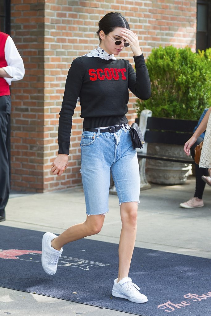 Mẫu quần jeans với phom dáng ôm cùng chiều dài ngắn trên gối được nhiều chân dài thế giới lăng xê, trong đó có Kendall Jenner. Người đẹp diện quần cùng sweater logo đi kèm sneakers trắng đơn giản.