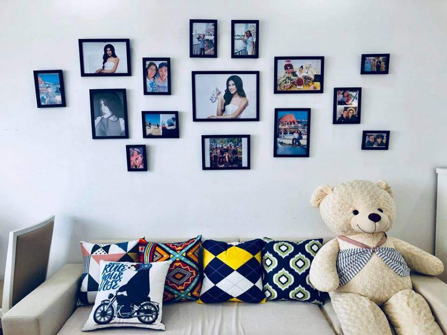 Tường phòng khách được người đẹp Bắc Ninh treo rất nhiều ảnh chụp cùng gia đình, người thân và bạn bè. Bộ gối ôm bắt mắt giúp không gian thêm nổi bật.    