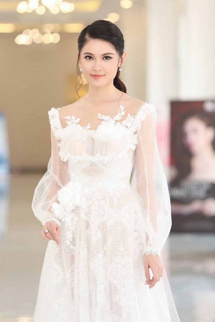 Á hậu Thùy Dung khoe làn da trắng ngần khi chọn một thiết kế váy trắng tinh khôi, kết hợp hài hòa giữa chất liệu voan lưới và ren.    