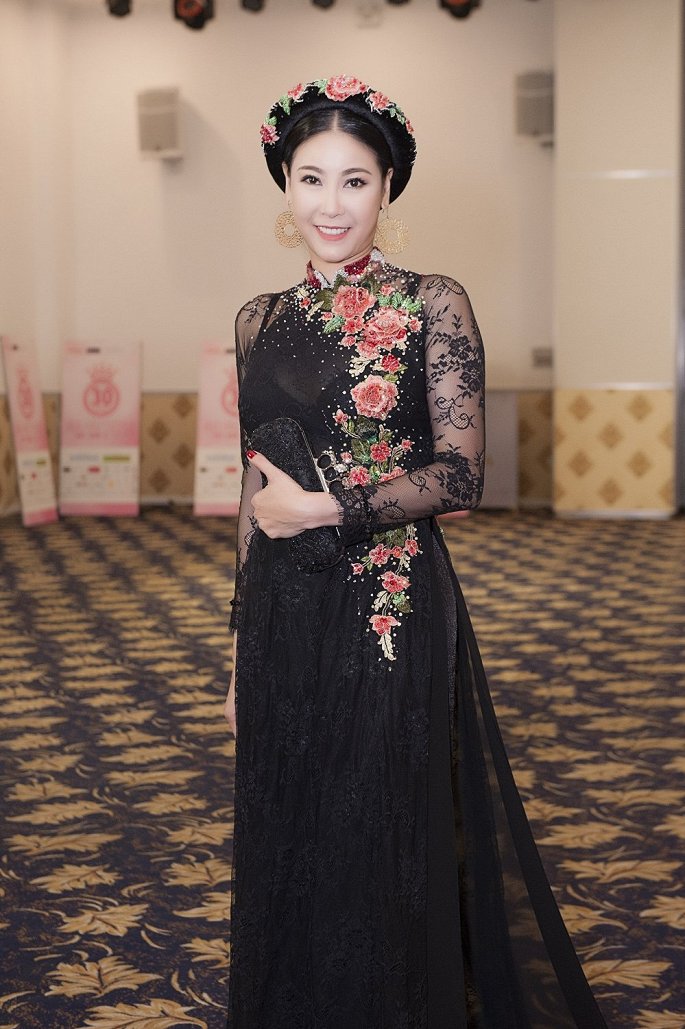 Hoa hậu Hà Kiều Anh ghi điểm không chỉ nhờ nhan sắc trẻ trung mà còn ở bộ áo dài đen sang trọng với những chi tiết hoa được đính nổi trên nền vải, đặc biệt là hoa đỏ tạo điểm nhấn cho tổng thể.    