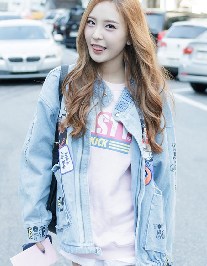 Nahyun (Sonamoo) nổi bật cùng áo thun hồng pastel phom dài kết hợp áo khoác jean tông màu sáng, đính sticker đủ màu sắc.  