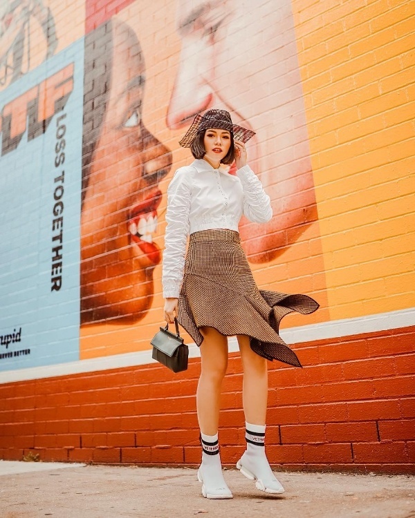  Tận dụng áo sơ mi trắng basic quen thuộc, Olivia Lazuardy mix cùng với chân váy ngắn bất đối xứng. Không phải giày cao gót nữ tính, cô tạo thêm điểm nhấn cho set đồ bằng đôi giày bệt thoải mái.    
