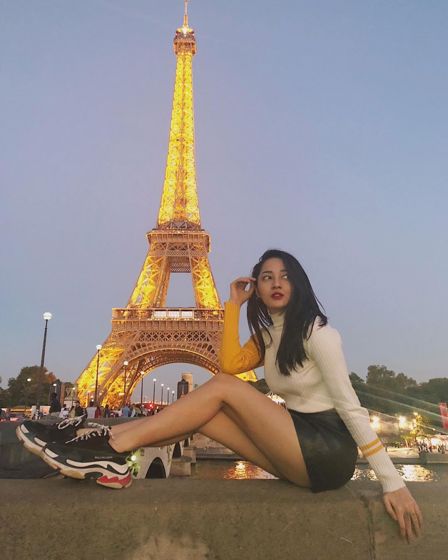 Vi vu du lịch ở Paris, ca sĩ Bảo Anh chọn cho mình chiếc áo len cách điệu phần tay phối với chân váy da cùng giày Balenciaga để thêm phần năng động.  