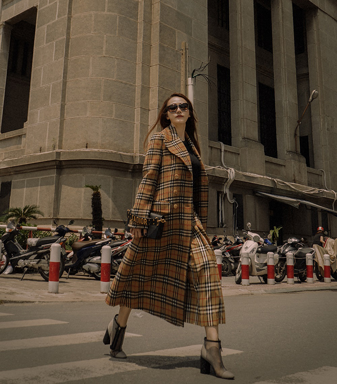 Set đồ kẻ caro đặc trưng của Burberry dễ dàng biến Ngân Khánh trở thành “mợ chảnh” hàng hiệu nhờ vào cách mix&match không thể chuẩn hơn với boots gót thô Chanel, túi xách Dior và mắt kính cực xịn Chanel.  