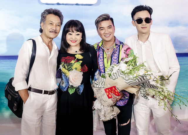 Ca sĩ Hương Lan và chồng đến chúc mừng sinh nhật ca sĩ Đàm Vĩnh Hưng, nữ nghệ sĩ nổi bật với áo dài hoa tươi rực rỡ.  
