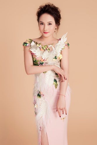  Gam màu trắng và hồng pastel của trang phục làm nổi chi tiết hoa tươi tắn kèm chi tiết chim phụng được đính cầu kỳ.   