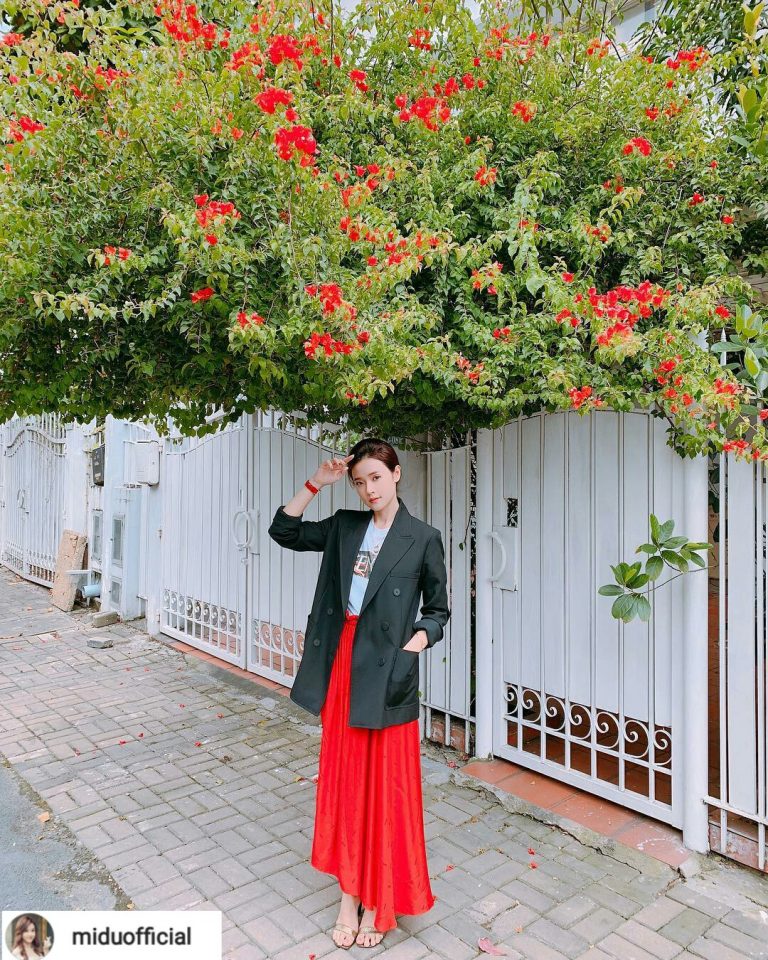Midu vẫn luôn ngọt ngào và dịu dàng. Chân váy xòe dài màu đỏ được kết hợp cùng áo thun trắng. Áo blazer đen khoác ngoài thêm phong cách.    