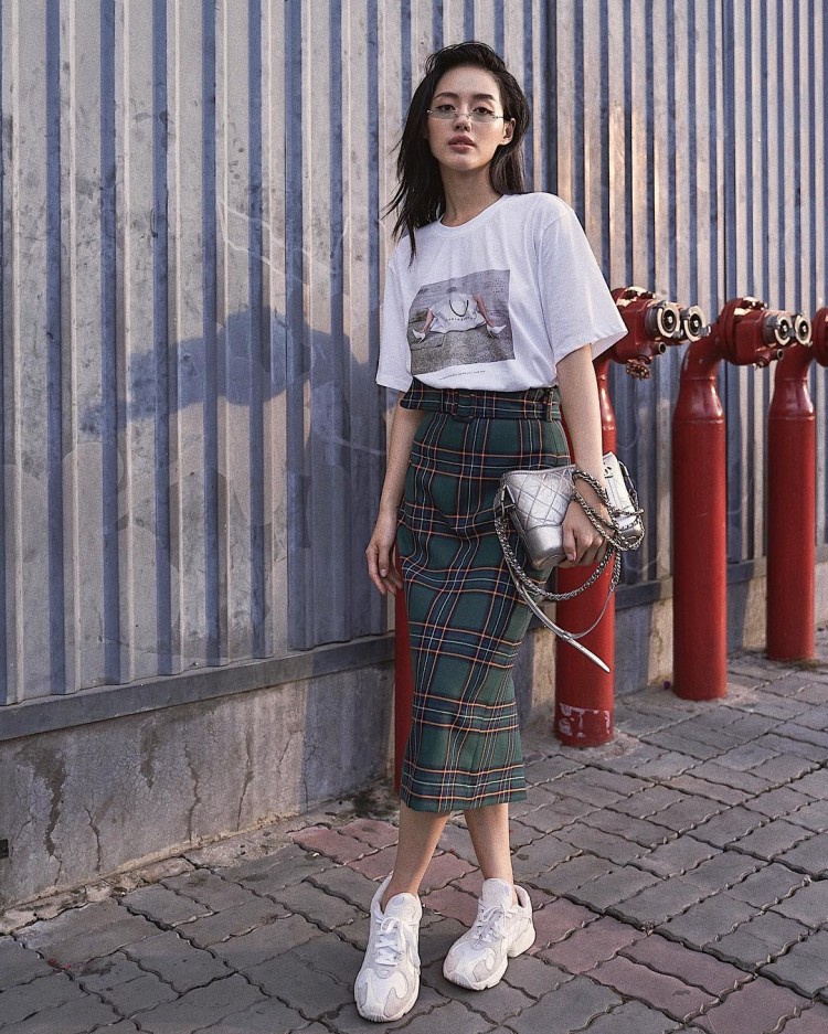 Khánh Linh The Face lại tạo sức hút từ chiếc túi Chanel gam màu bạc trên nền áo phông và chân váy ôm ca-rô.  