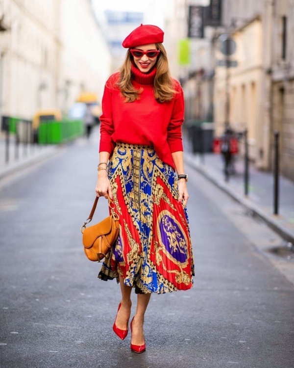Alexandra Lapp lăng xê tông đỏ ấm áp, nổi bật. Fashionista phương Tây phối áo len cổ lọ cùng chân váy midi in họa tiết ấn tượng, thêm phụ kiện là mũ nồi và giày cao gót ton sur ton.    