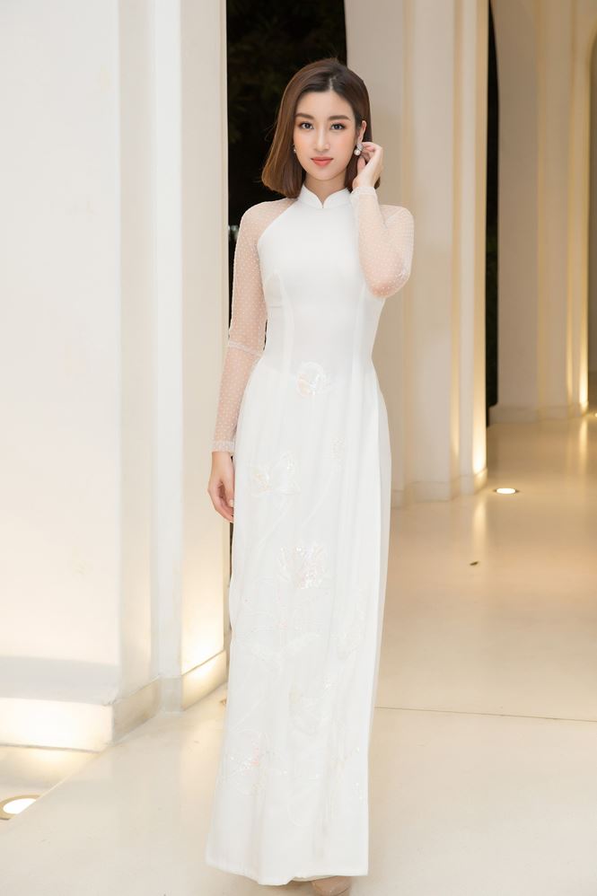 Cùng diện áo dài trắng, nhưng Đỗ Mỹ Linh lại chọn thiết kế trơn thanh nhã, phối hai loại chất liệu vải.  