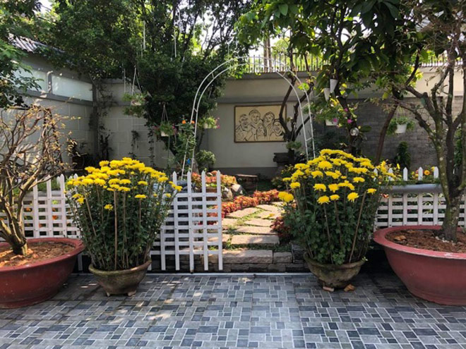Không gian hoa tươi mang lại sức sống cho căn nhà của hai nghệ sĩ. Trong vườn, một bức vẽ gia đình được treo ngay chính diện tạo cảm giác ấm áp, mọi người luôn nghĩ về nhau.    