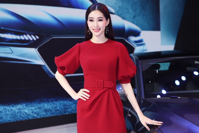Xuất hiện tại Triển lãm Ôtô Việt Nam 2018, Hoa hậu Thu Thảo nổi bật bởi phong cách thanh lịch, làn da trắng muốt khi diện bộ đầm đỏ kín đáo. Nhan sắc của cô đúng là 