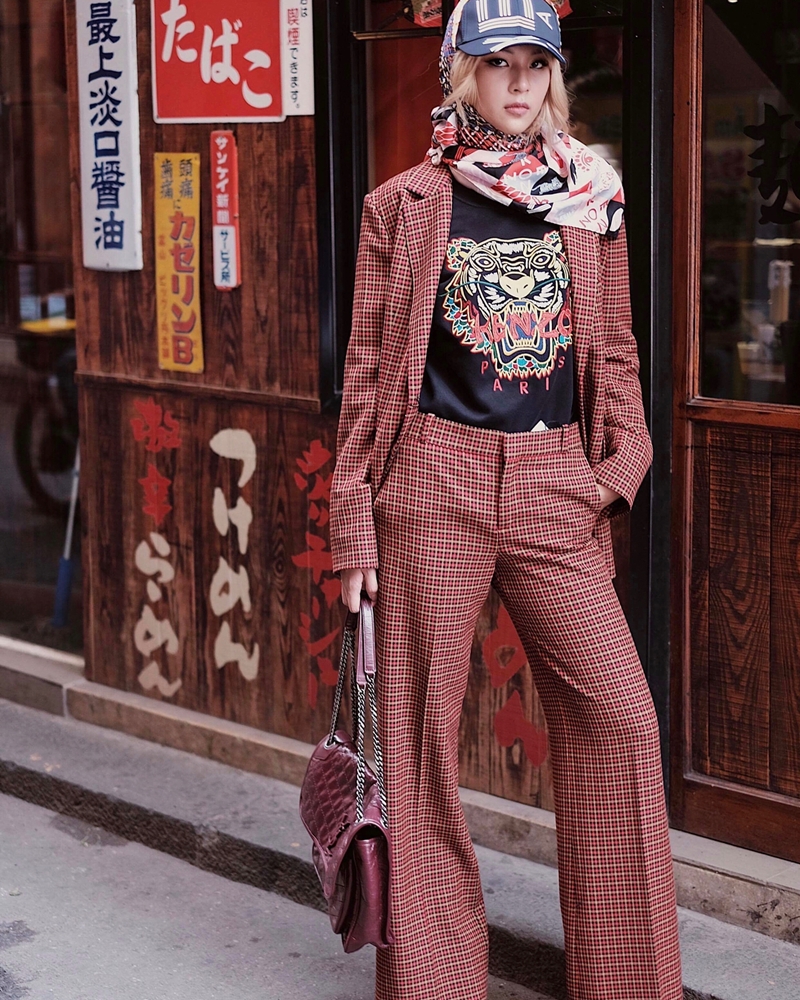 Ưu ái thiết kế suit kẻ tông đỏ trầm, mix cùng áo phông blazer và khăn cổ, Phí Phương Anh hoàn thiện set đồ mang dấu ấn thập niên 70 bằng chiếc túi vintage tiệp màu của Saint Laurent.    