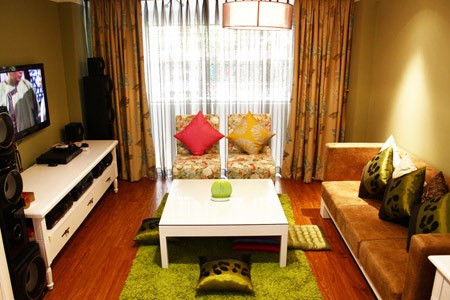 Phòng khách ấm cúng và yên tĩnh với tông màu trắng, điểm nhấn là tấm thảm trải sàn màu xanh.  