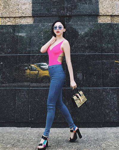 Tóc Tiên dùng áo tắm hồng neon kiểu cut-out kết hợp skinny jeans, sandals đế thô và túi hàng hiệu.    