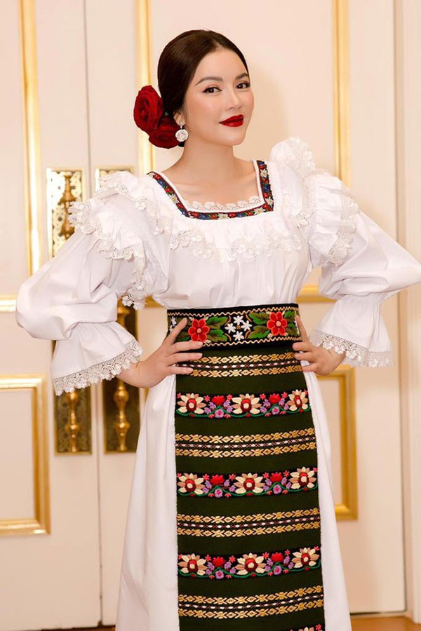 Bỏ qua những ồn áo đó, mới đây Lý Nhã Kỳ đã tham dự một sự kiện ngoại giao trong vai trò Lãnh sự danh dự nước Romania tại TP.HCM. Nữ diễn viên chọn bộ trang phục màu trắng kết hợp hoa văn rực rỡ mang đậm truyền thống của Romania.  