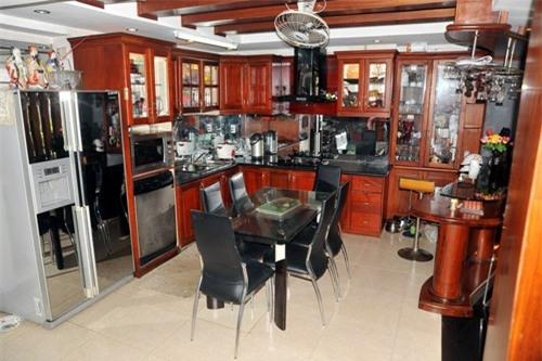 Phòng ăn được sử dụng đồ gỗ đắt đỏ. Tông màu chủ đạo vẫn là màu cam đỏ của gỗ ấm áp và màu đen, xám của nội thất.