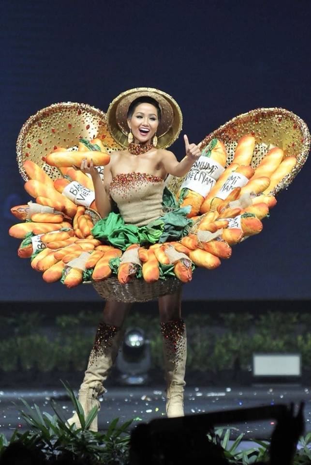 Trên sân khấu, người đẹp Việt Nam tự tin trình diễn, kết hợp một tay giơ cao ổ bánh mì - cảm hứng chủ đạo của trang phục. Cuối đường băng, H'Hen tạo dáng và nở nụ cười rạng rỡ với khán giả.  